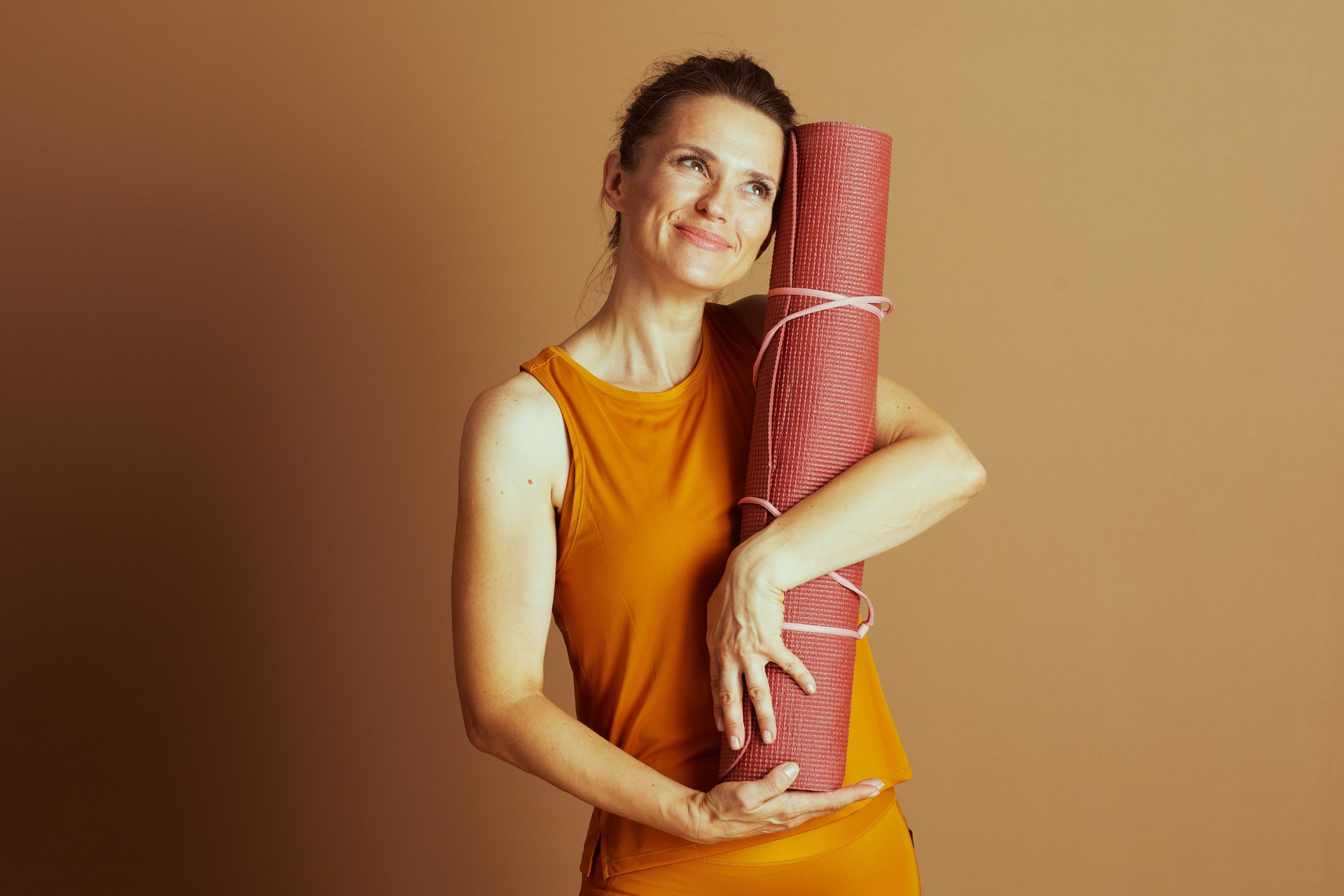 Reflective Woman with Yoga Mat and Upward Gaze